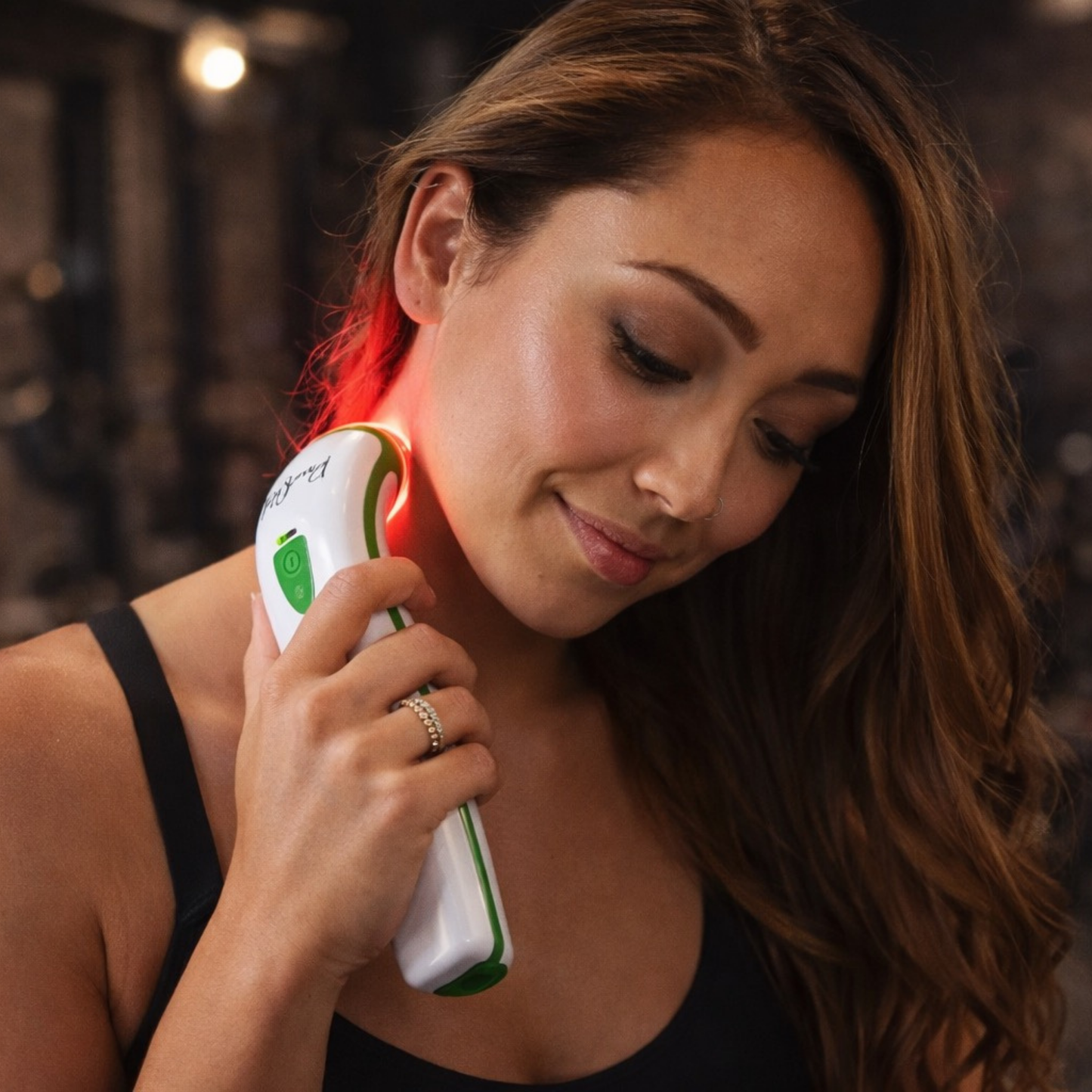 woman using photizo red light therapy pain relief device on neck 