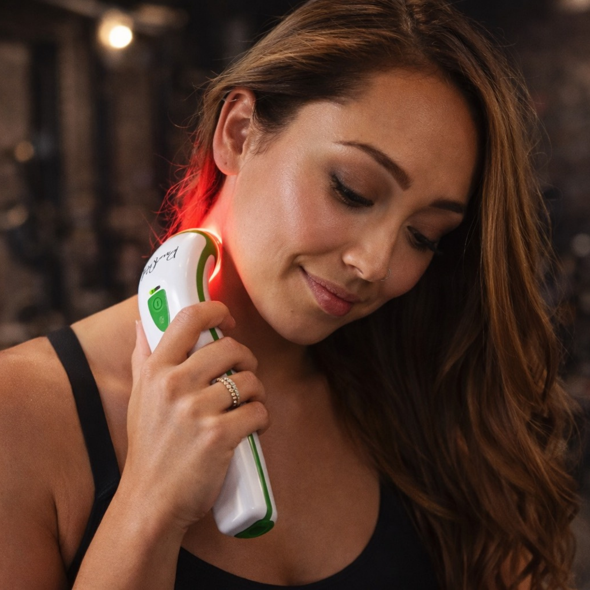 woman using photizo red light therapy pain relief device on neck 